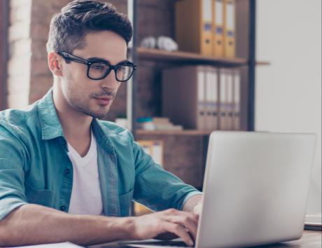 Persona mirando su portátil para ilustrar la creación de un CV con formato funcional