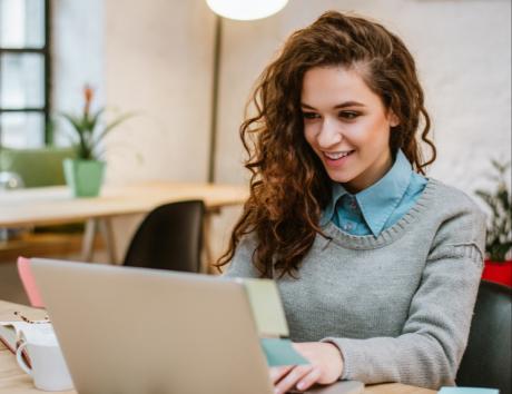Ragazza di fronte a schermo del computer per indicare come scrivere un curriculum senza esperienza