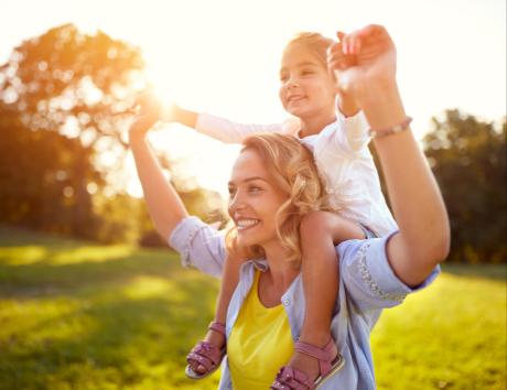Imagen de una mujer con un niña a hombros para ilustrar los hijos en el currículum