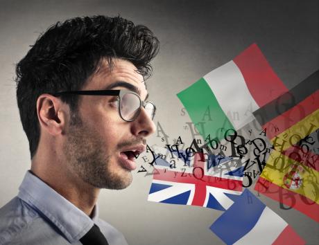Profilo di giovane con bandiere di diverse nazioni e lettere dell'alfabeto sullo sfondo per indicare come inserire le lingue straniere nel curriculum