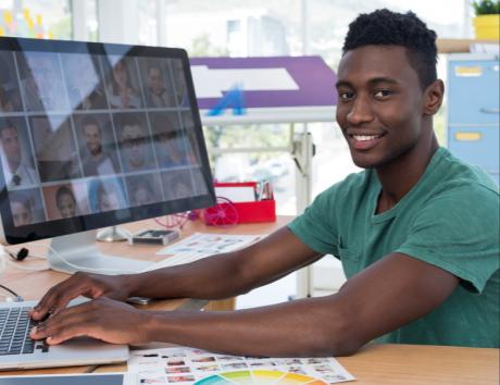 Jeune homme travaillant sur un ordinateur, illustrant les compétences à mettre en avant sur un CV.