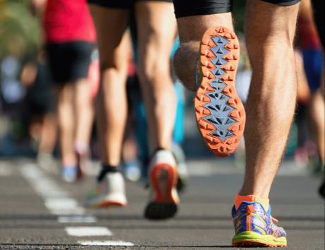 Primo piano su gambe di persone che corrono con scarpe da ginnastica come esempio di hobby e interessi per CV