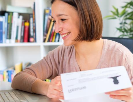 Femme lisant un curriculum avec titre, illustrant comment rédiger un titre de CV efficace.