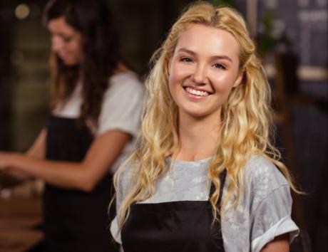 Ragazza sorridente in abbigliamento da lavoro per indicare come presentare le esperienze lavorative e professionali sul curriculum vitae