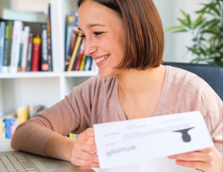 Mujer sonriendo mientras sostiene un currículum para ilustrar un título de CV eficaz