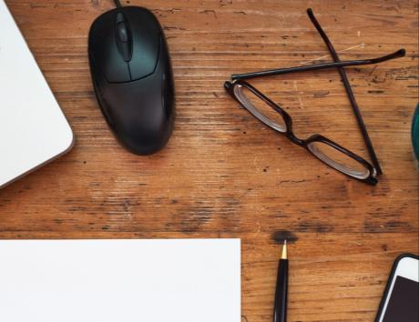 Espace de travail avec ordinateur et accessoires, illustrant la rédaction d’un CV chronologique ou antéchronologique