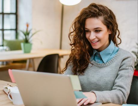 Jeune femme rédigeant un CV sans expérience professionnelle sur son ordinateur portable.
