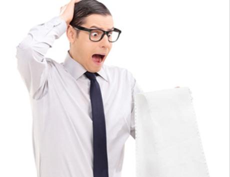 Uomo con cravatta e occhiali osserva preoccupato un foglio molto lungo suggerendo il tema dell'articolo dedicato a lunghezza CV